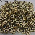 Miçanga Cubo 5mm - Ouro / Letra Preta - 24gr