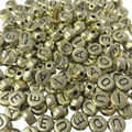 Miçanga Círculo Vogais 6mm - Ouro / Vogais Preta - 24gr